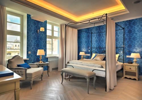 里加瑞莱斯骑士酒店的卧室拥有蓝色的墙壁,配有一张床和椅子