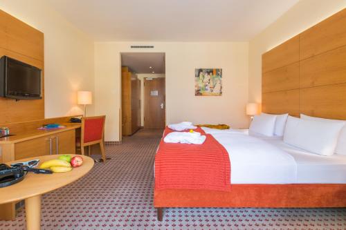 瓦尔内明德惠布纳公园酒店的酒店客房设有一张大床和一张桌子。