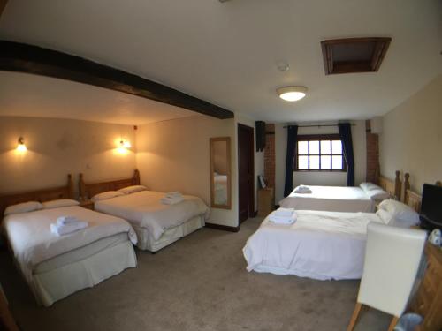 Sutton upon Trent尼尔森爵士酒店的酒店客房设有三张床和窗户。