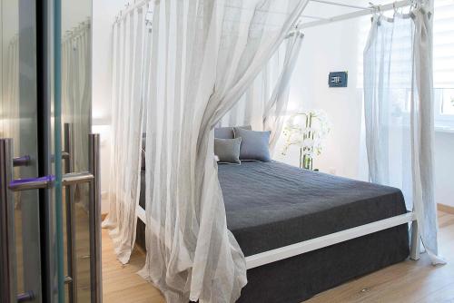 罗马Relais Dolcevita的卧室配有带白色窗帘的天蓬床