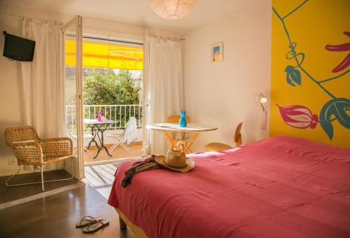 滨海卡涅Le Val Duchesse Hotel & Appartements的一间卧室设有红色的床、一张桌子和一个庭院。