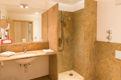 巴特格勒嫩巴赫格润因伯克兰德酒店的一间带水槽和淋浴的浴室