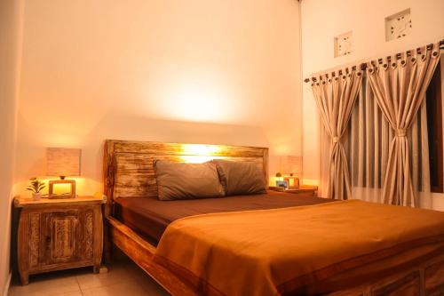 乌鲁瓦图乌玛武吉酒店的一间卧室配有一张带木制床头板的床