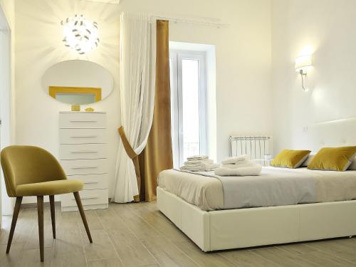 塔兰托Duca70 "Suite Home"的白色卧室配有床和椅子