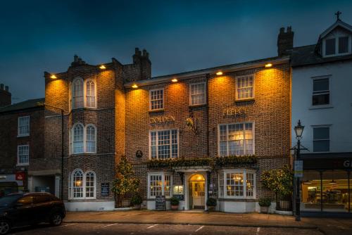 瑟斯克The Golden Fleece Hotel, Thirsk, North Yorkshire的一座带灯的大砖砌建筑