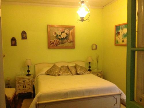 圣费尔南多雷诺阿旅馆的一间卧室设有一张黄色墙壁的床