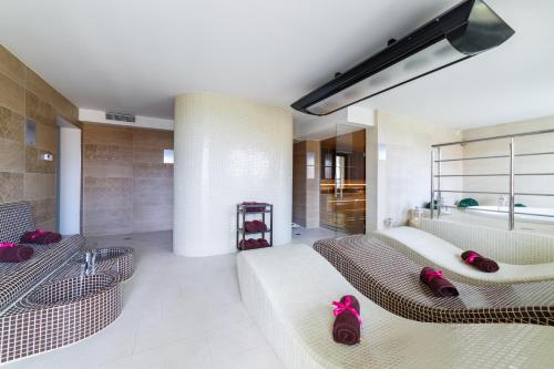 奥克宁卡Hotel Sanvit Lake Resort & Spa的客厅配有两张沙发和一个浴缸