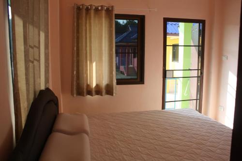 清孔帕纳卡龙民宿的一间卧室设有一张床和两个窗户。