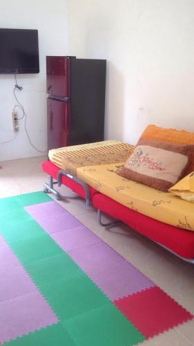 班达楠榜Olivine House的一间卧室配有床和色彩缤纷的地毯。