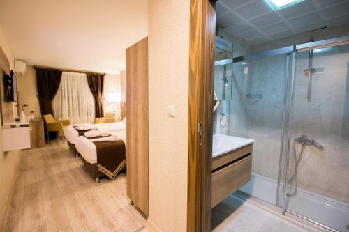 内夫谢希尔商务酒店的一间卧室配有一张床,浴室设有淋浴。