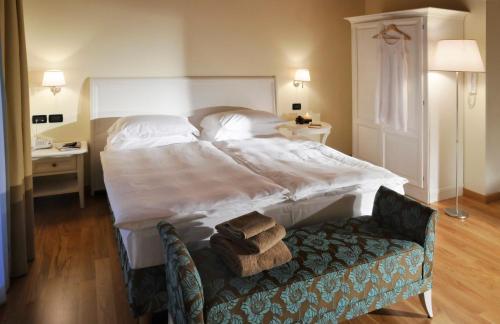 巴索维扎狄彭当斯利帕酒店的卧室配有一张白色大床和一把椅子