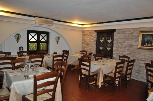 塞拉圣布鲁诺卡拉布里亚公爵酒店的一间设有桌椅的用餐室和砖墙