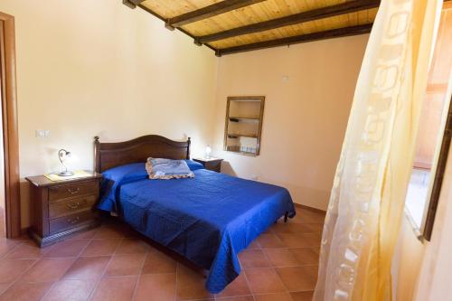 莫塔卡玛斯特拉Profetina Village的一间卧室配有一张带蓝色床罩的床