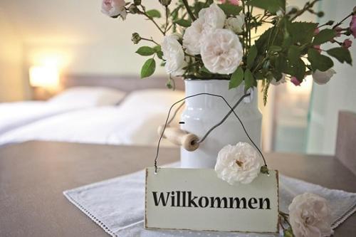 佩尔沃姆Hotel Landhaus Leuchtfeuer Nordseeinsel Pellworm的白色花瓶,桌子上有一个标志