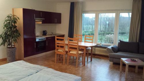 佩尔沃姆Hotel Landhaus Leuchtfeuer Nordseeinsel Pellworm的客厅设有厨房、桌子和椅子