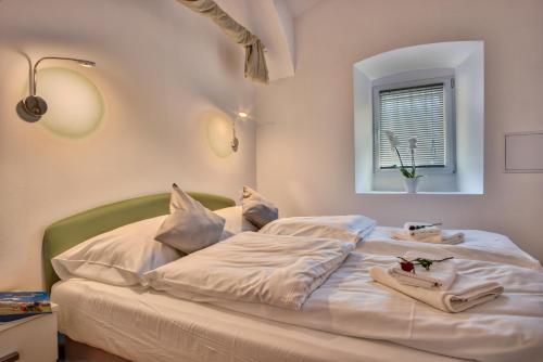 卢布尔雅那Apartment Pod velbi的卧室配有白色床和毛巾