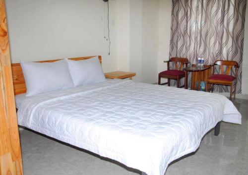 岘港15A旅舍的卧室配有白色的床、椅子和桌子