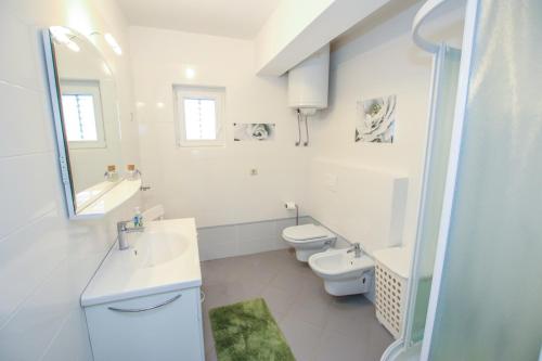 波雷奇Apartman Mila的白色浴室设有2个卫生间和水槽
