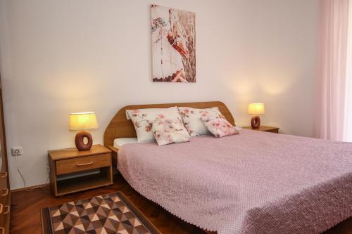 波雷奇Apartman Mila的一间卧室配有一张带粉色床单和枕头的床。