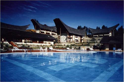 Makale萨希德托拉雅酒店的大型建筑前的大型游泳池