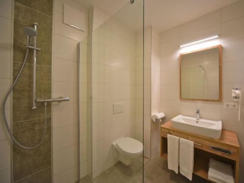 米尔施塔特Hotel Berghof的带淋浴、卫生间和盥洗盆的浴室