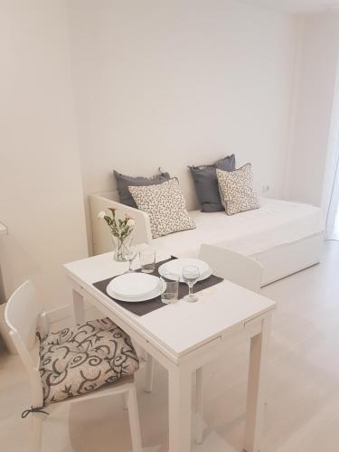 洛斯克里斯蒂亚诺斯洛斯克里斯蒂亚诺斯公寓享受，放松和生活的海洋！的白色的客厅配有白色的桌子和沙发