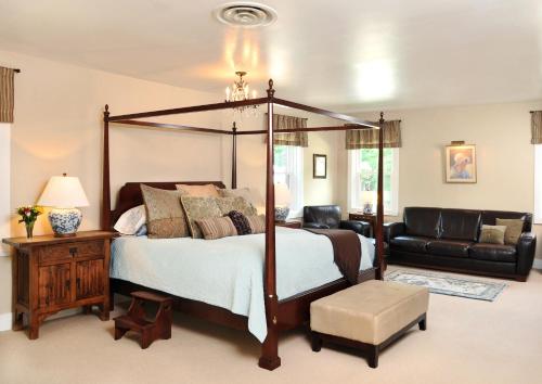 卡南代瓜1795 Acorn Inn Bed and Breakfast的一间卧室配有四柱床和沙发