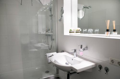 黑尔戈兰岛Appartements am Binnenhafen的白色的浴室设有水槽和淋浴。