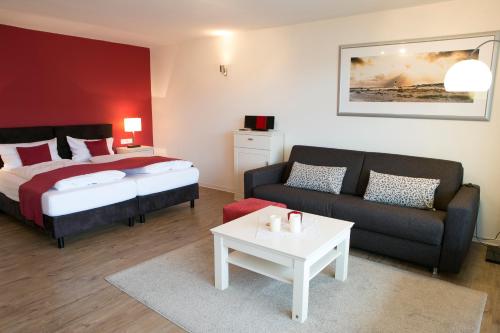 黑尔戈兰岛Appartements am Binnenhafen的一间卧室配有一张床、一张沙发和一张桌子