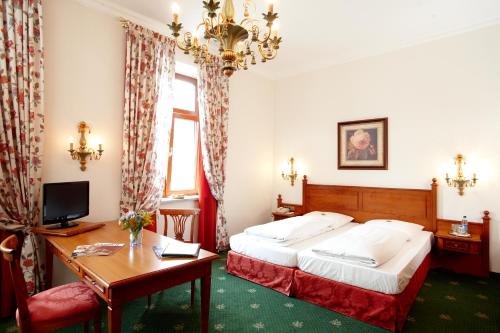 慕尼黑格鲁瓦尔德酒店的酒店客房配有一张床、一张书桌和一台电脑