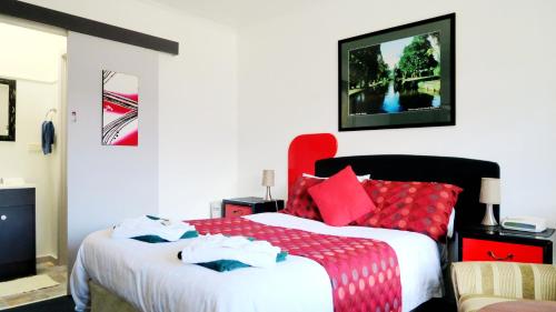 新诺福克枢纽汽车酒店的一间卧室配有两张带红色枕头的床