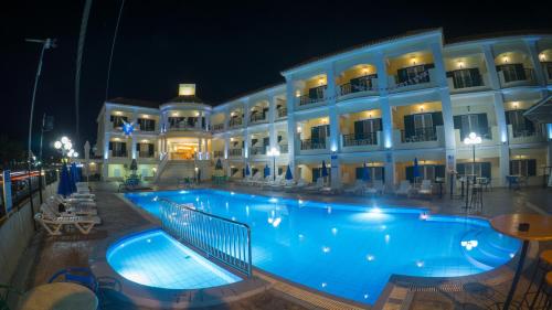 拉加纳斯阿芙罗狄蒂酒店的一座大楼前的大型游泳池