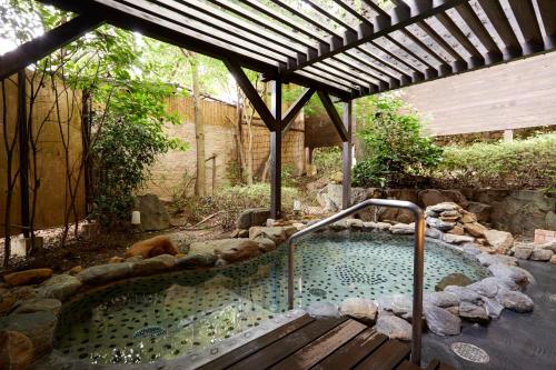 嬉野市汉密尔顿嬉野酒店的花园内的热水浴池,设有木甲板