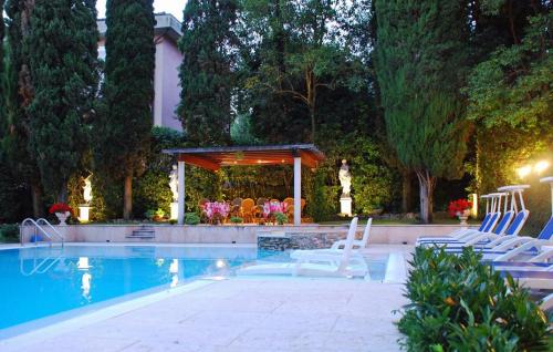 西尔米奥奈Hotel Désirée - Garda Lake Collection的一个带白色椅子的游泳池和一个凉亭
