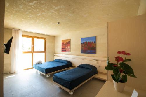 法维尼亚纳白色凯芙酒店的一间卧室设有两张床和盆栽植物