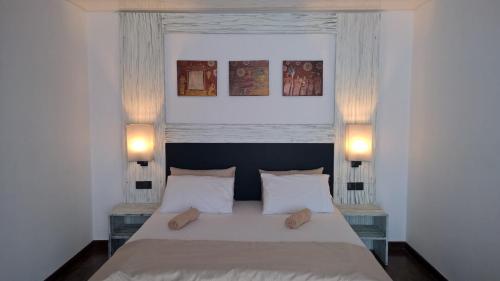哈普特莱The Nest by Amarasinghe's的一间卧室配有一张带两盏灯的大型白色床。