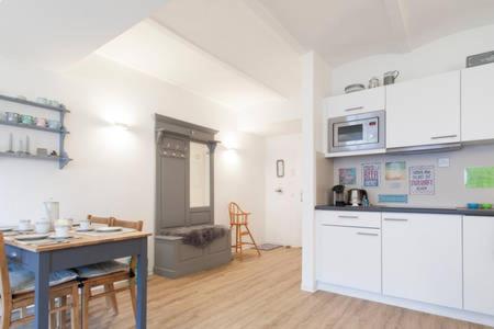 纽伦堡Stadt-Apartment的一间厨房,内设白色橱柜和一张桌子