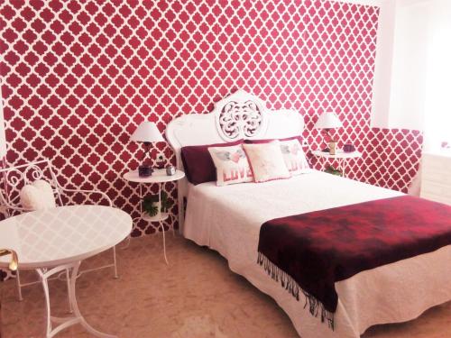 科尔多瓦Vintage apartment的一间卧室配有一张床和红色图案的墙壁