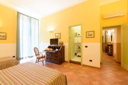 那不勒斯梅尔杰利纳酒店的一间卧室配有一张床、一张书桌和一面镜子