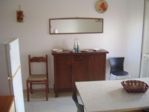 莱乌卡Appartamento Lucio Leuca的配有桌椅和镜子的客房