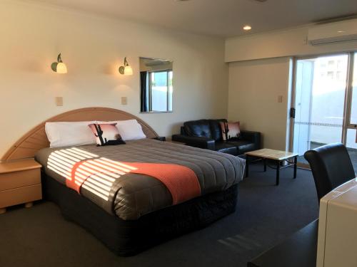 吉斯伯恩太平洋港汽车旅馆 的配有一张床和一把椅子的酒店客房