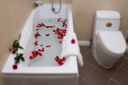 潘切兰花精品海滩度假村 的浴室设有卫生间,上面有红色的鲜花