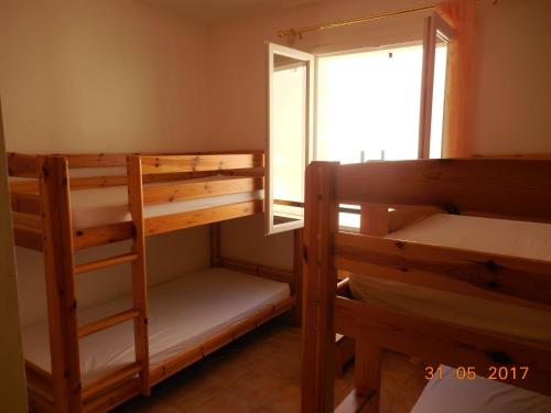 Le BarrouxLes Cigales du Ventoux的客房设有两张双层床和一扇窗户。