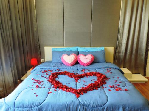 八打灵再也夏娃套房公寓的红花床上有两颗心