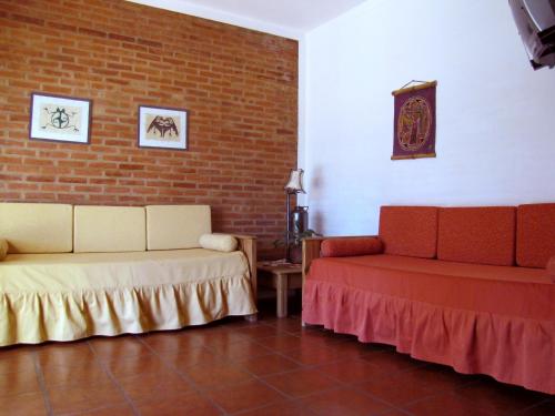 米娜克拉韦罗科斯塔塞拉纳公寓酒店的一间设有两张床和砖墙的房间