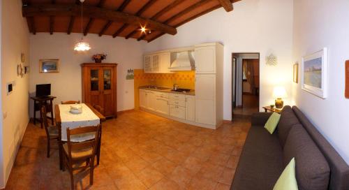 瓦达Agriturismo Le Pescine的厨房以及带沙发和桌子的客厅。