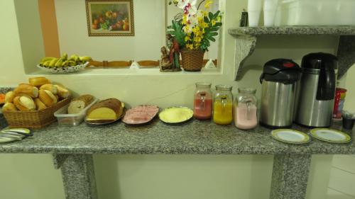 卡舒埃拉保利斯塔Pousada Lirio do Vale的厨房柜台提供面包和果汁