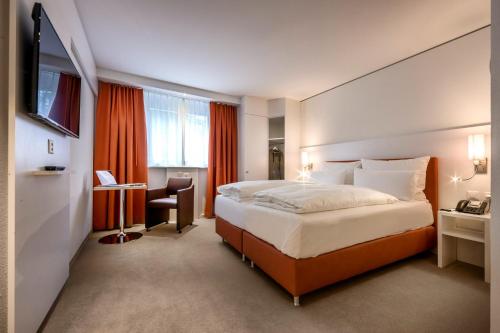 伦策海德赖伊生活方式酒店的酒店客房设有一张大床和一张书桌。