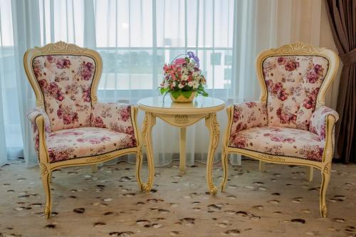 北马马亚-讷沃达里Almar Luxury的两把椅子和一张带花瓶的桌子