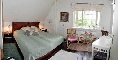 阿灵厄Danchelshus的一间卧室配有一张床、一张书桌和一个窗户。